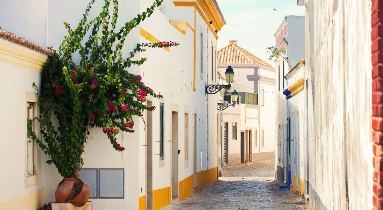 Cobblestone street and whitewashed buildings in Faro, Portugal